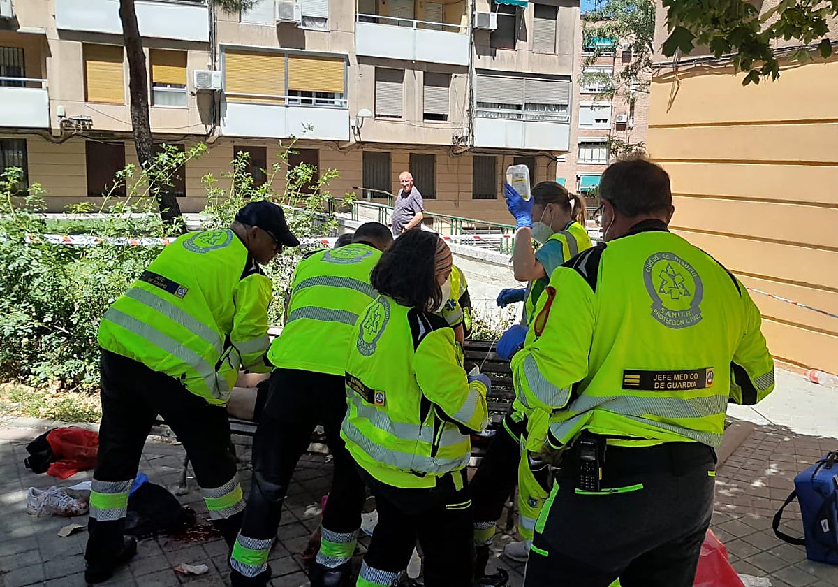 Sanitarios de Samur-Protección Civil atienden al herido en la calle de Marcelo Usera