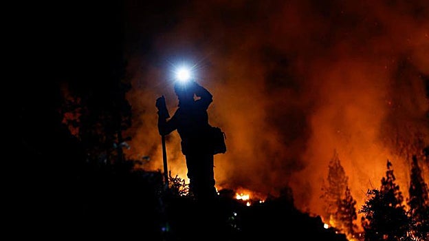 Un bombero durante la noche de este miércoles entre las llamas del monte Arafo