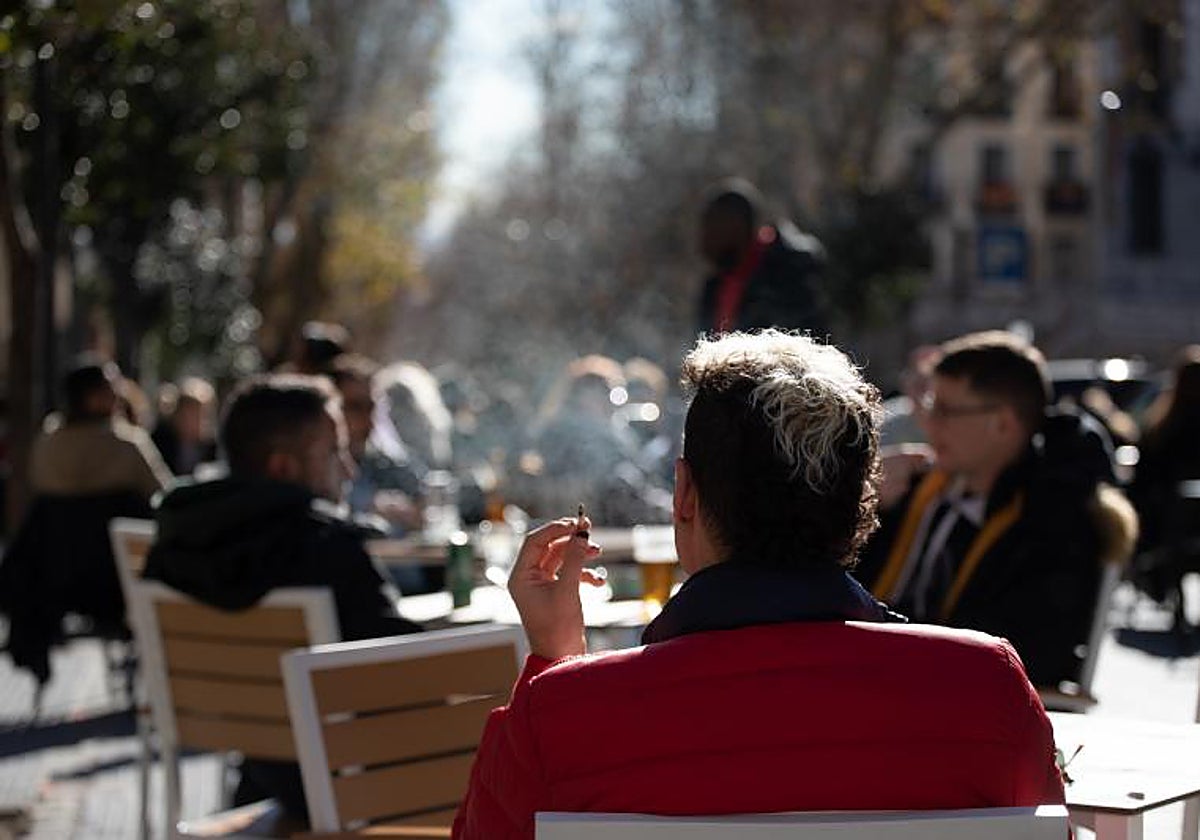 Imagen de archivo de un hombre fumando en la terraza de un bar