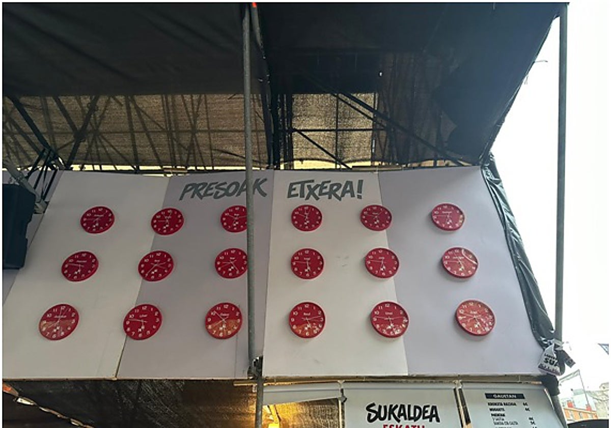 En la caseta han colocado un mural con relojes que simulan la cuenta atrás para la excarcelación de los terroristas