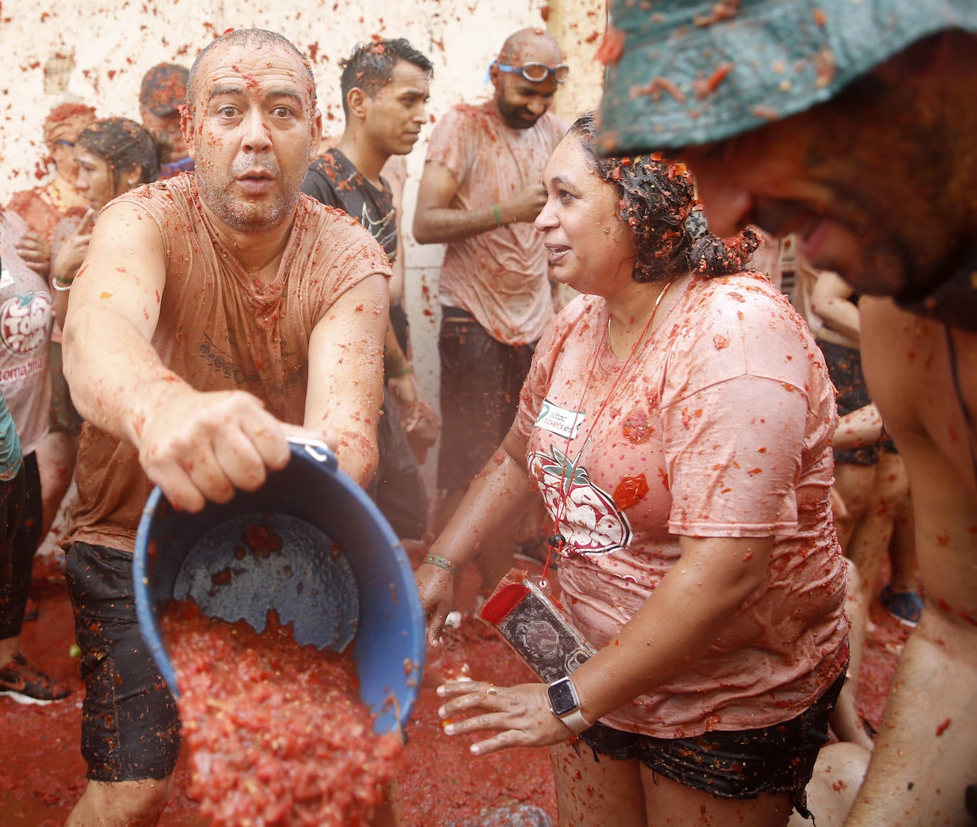 Varias personas cubiertas de tomate durante la fiesta de La Tomatina