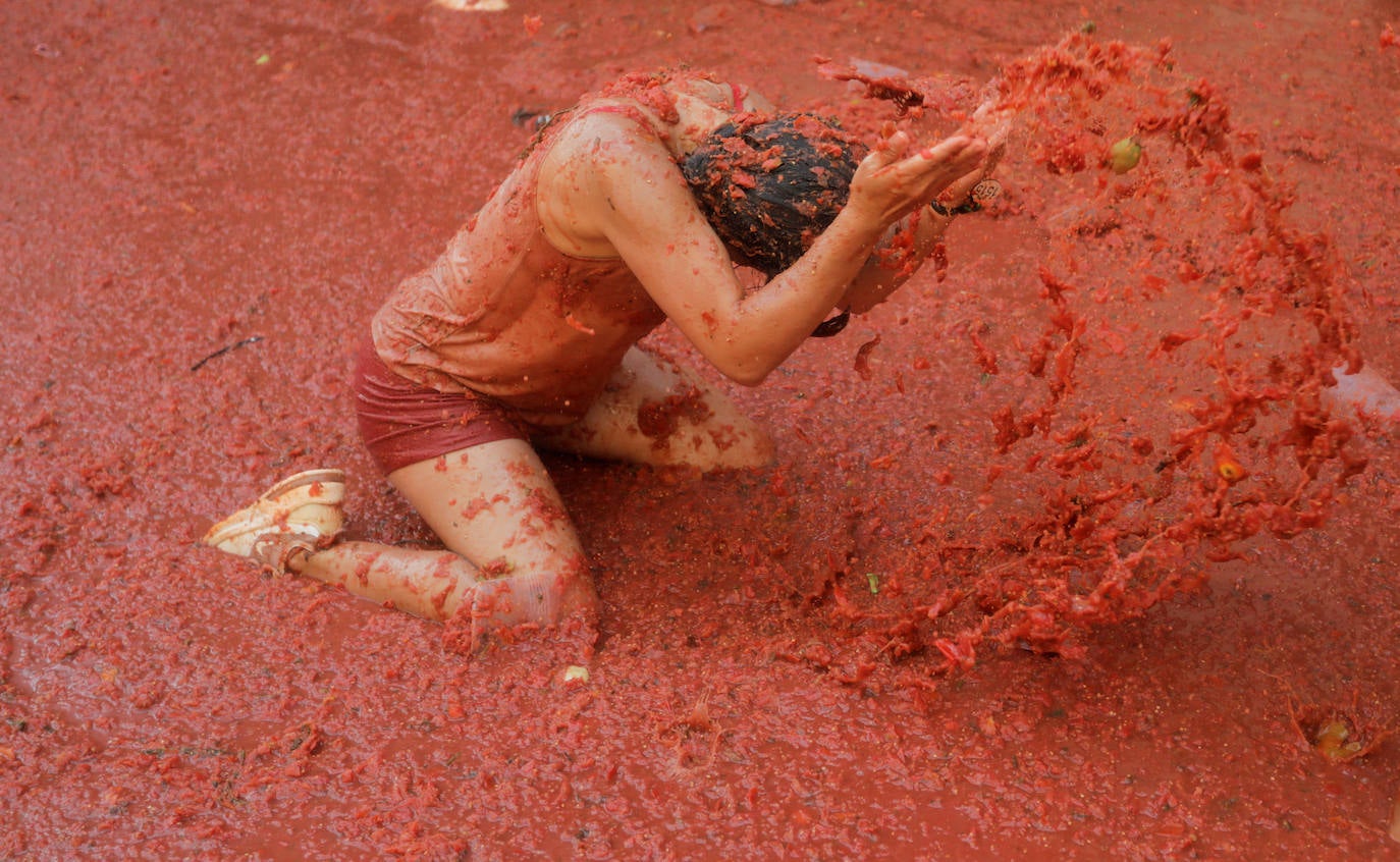 Una joven recibe una descarga de tomate triturado en la tradicional Tomatina