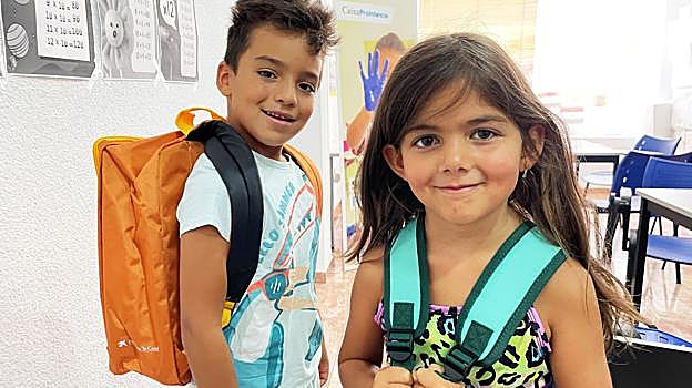 Dos niños, con material escolar donado por la Caixa
