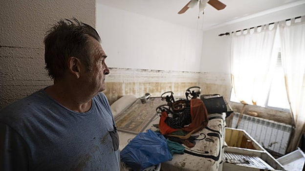 Un afectado enseña el interior de su vivienda, destrozada por la DANA