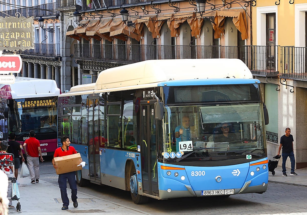 Uno de los autobuses cedidos por el Ayuntamiento de Madrid a la ciudad de Toledo: detrás uno de los vehículos que se ha salvado de la DANA