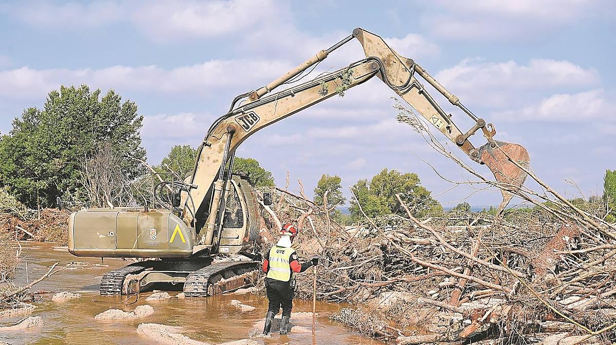 Una excavadora y un trabajador durante el dispositivo de búsqueda