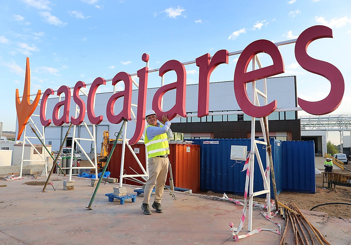El propietario de Cascajares, Alfonso Jiménez, levanta el rótulo que sobrevivió al incendio junto a la nueva fábrica