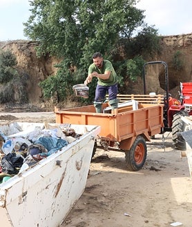 Imagen secundaria 2 - El alcalde revisa el estado de los puentes del municipio tras el temporal; una vecina recoge sus pertenencias dañadas por la gota fría en su casa; un operario tira escombros arrastrados por la DANA a un contenedor