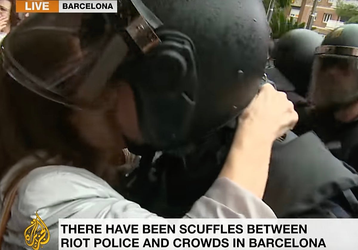 Fotograma en la que una manifestante besa a un policía el 1-O