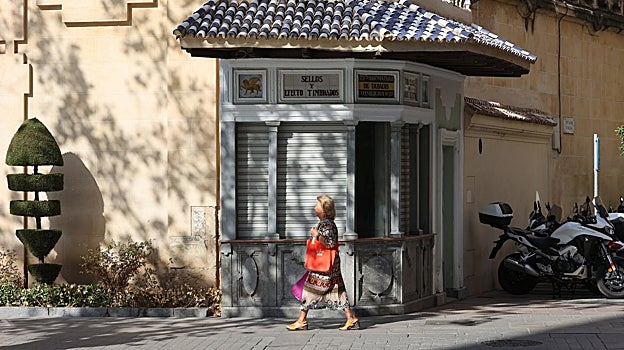 Una mujer pasa delante del quiosco de San Hipólito