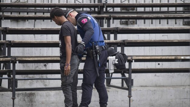 Un policía municipal registra a un pandillero en Lavapiés