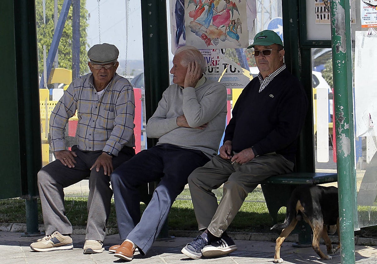 Tres mayores, en una marquesina de autobús