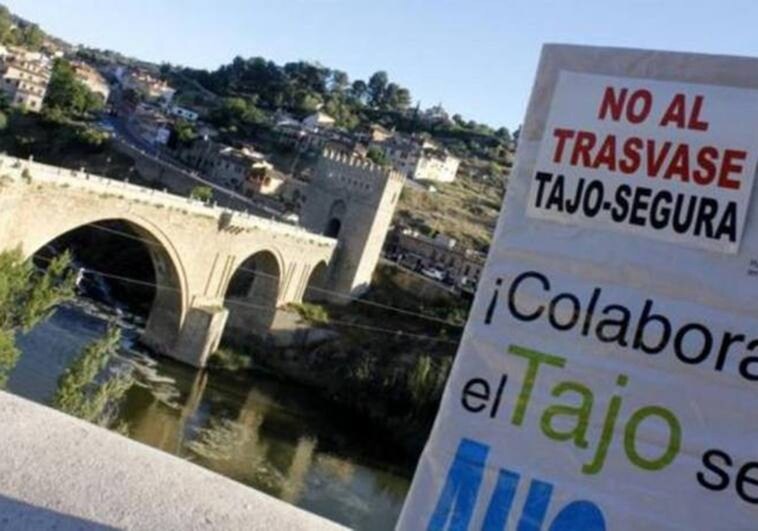 Cartel de manifestación contra los trasvases del Tajo al Segura junto al cauce del río en Toledo