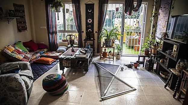 Un ventanal roto en la sala de estar de uno de los hogares afectados.