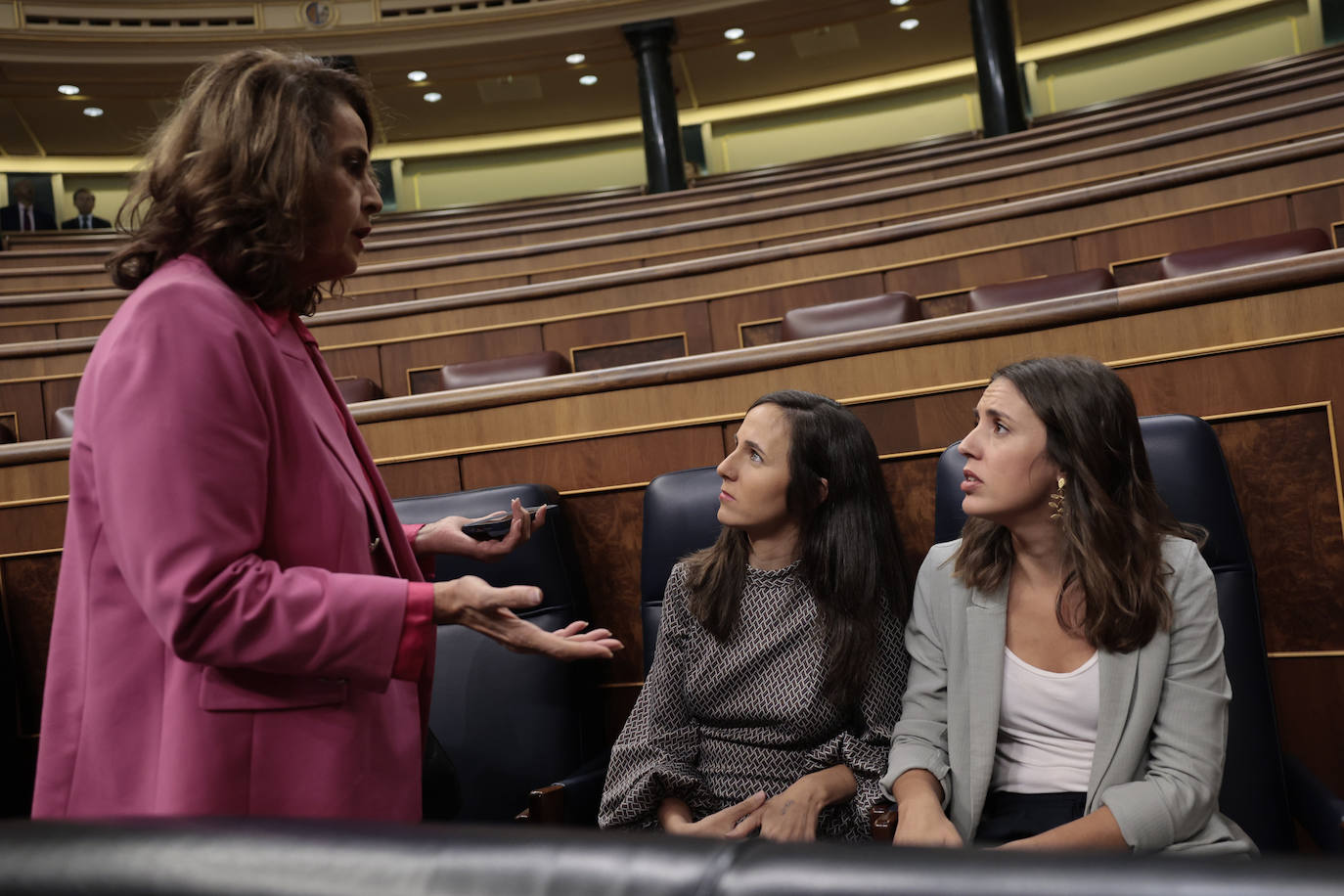 Las ministras Ione Belarra e Irene Montero, conversan con la diputada Carla Antonelli, antes del inicio de la primera sesión del debate de investidura