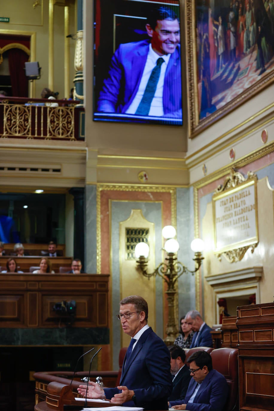 Pedro Sánchez proyectado riéndose en una pantalla gigante en otro momento del discurso del líder del PP