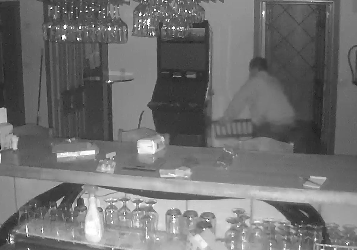 Uno de los ladrones destroza con una tapa de alcantarilla la máquina