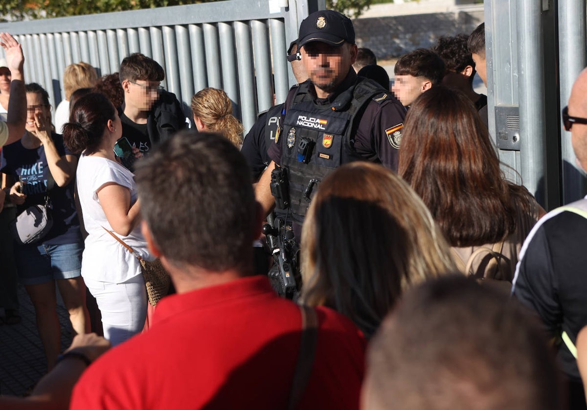 Un agente de Policía atiende a los familiares de los alumnos este jueves a las puertas del instituto