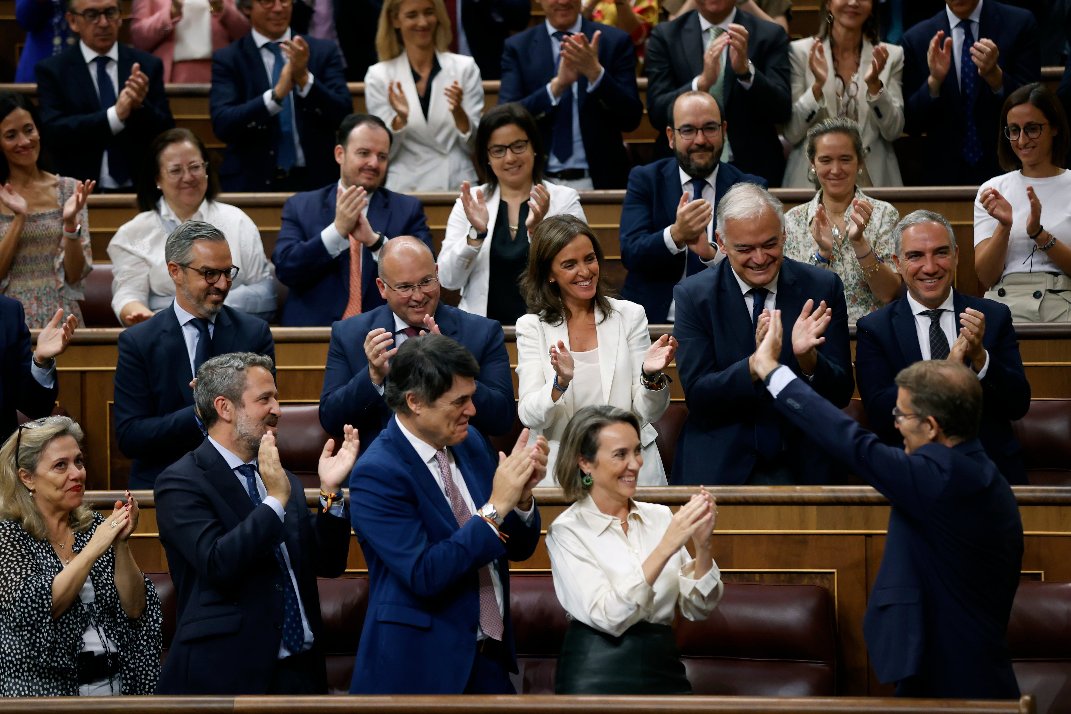 El líder del PP, Alberto Núñez Feijóo (d) recibe el aplauso de la bancada popular tras su intervención