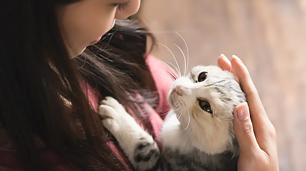 Imagen de una mujer abrazando a su gato