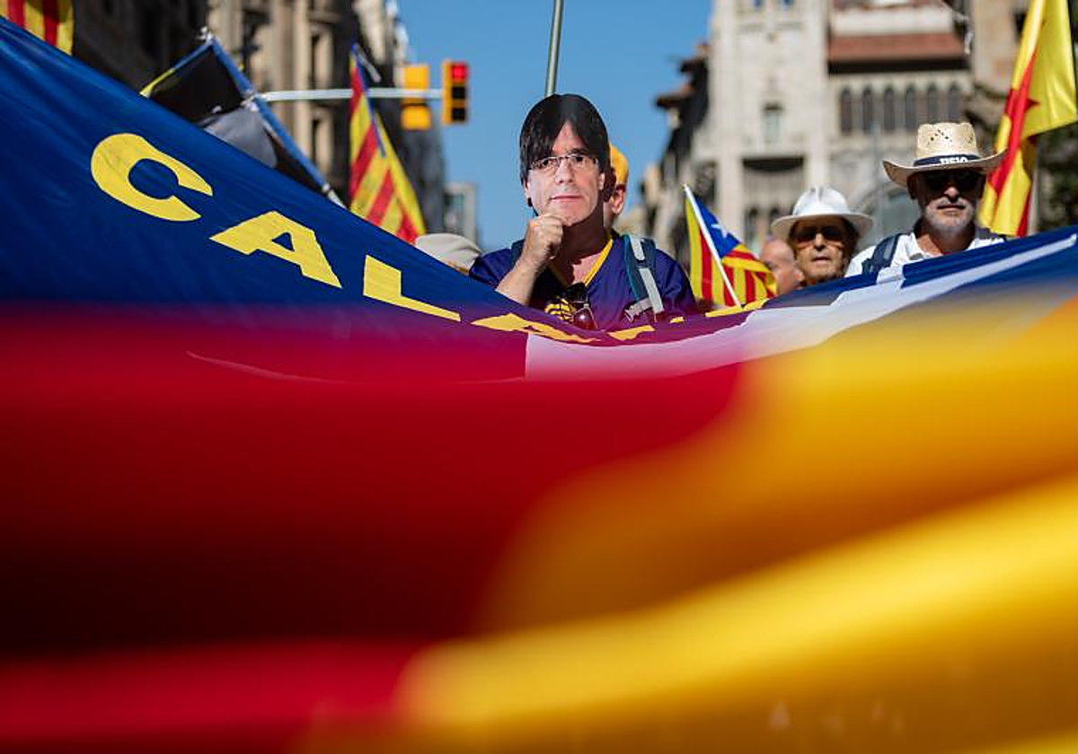 Un manifestante en la marcha de la ANC, hoy en Barcelona, con una careta de Carles Puigdemont