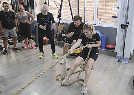 Imagen secundaria 1 - Arriba, Alejandro Rojas-Marcos empuja el trineo. Sobre estas líneas, dos integrantes del equipo practican la tracción y los burpees con peso