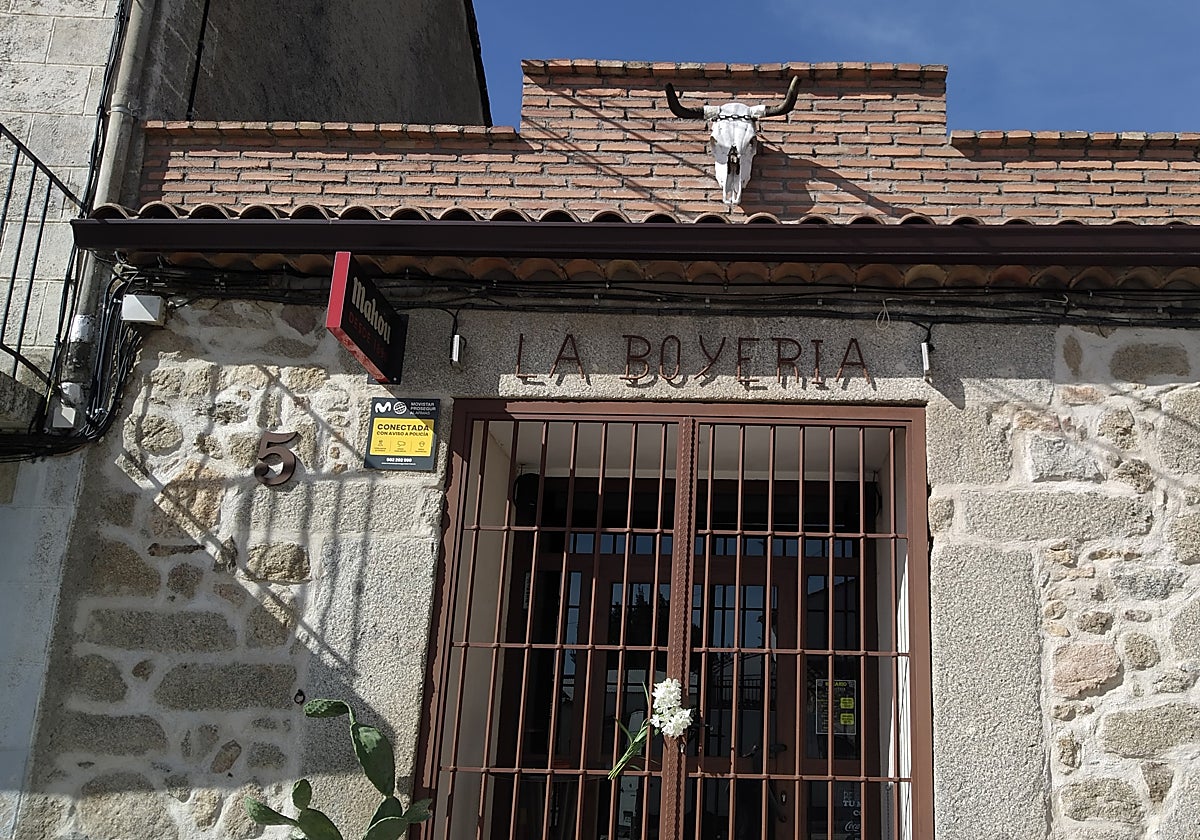 Unas flores blancas colocadas por unas vecinas en la reja del negocio que Belén regentaba en Pelahustán