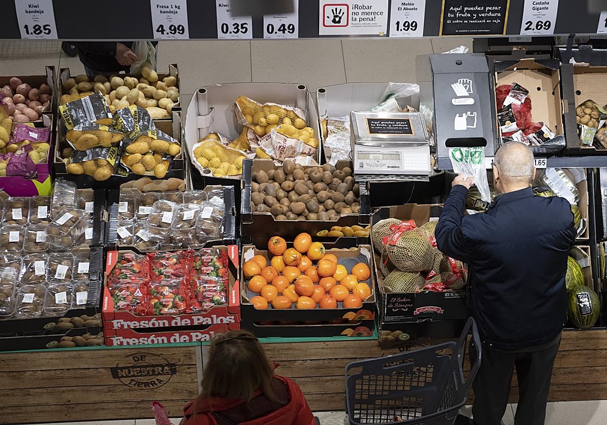 Un hombre conprando fruta en un supermercado