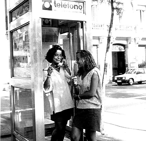 Dos jóvenes hablan en una cabina pública en1986