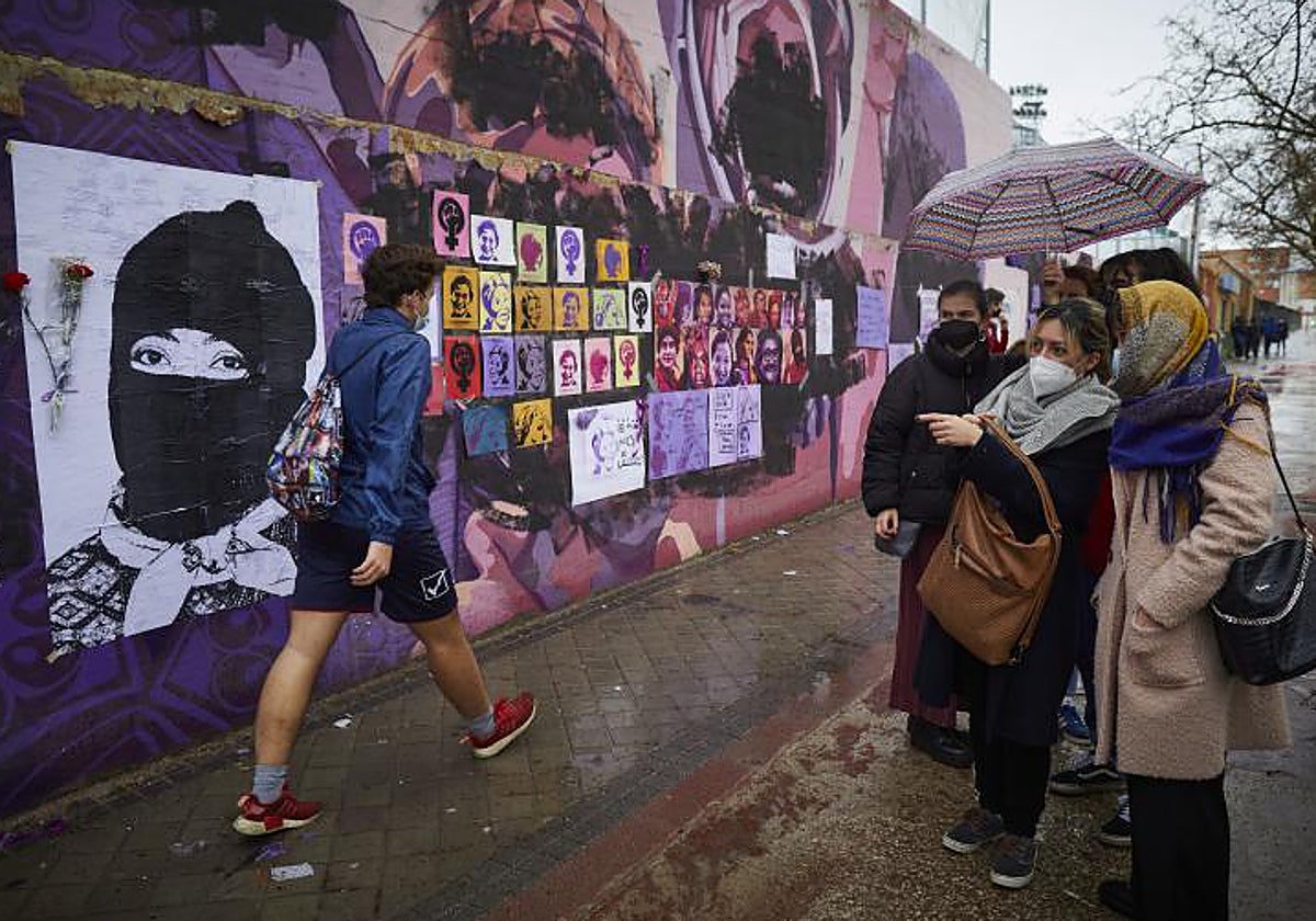 Varias personas observan el mural feminista de Ciudad Lineal