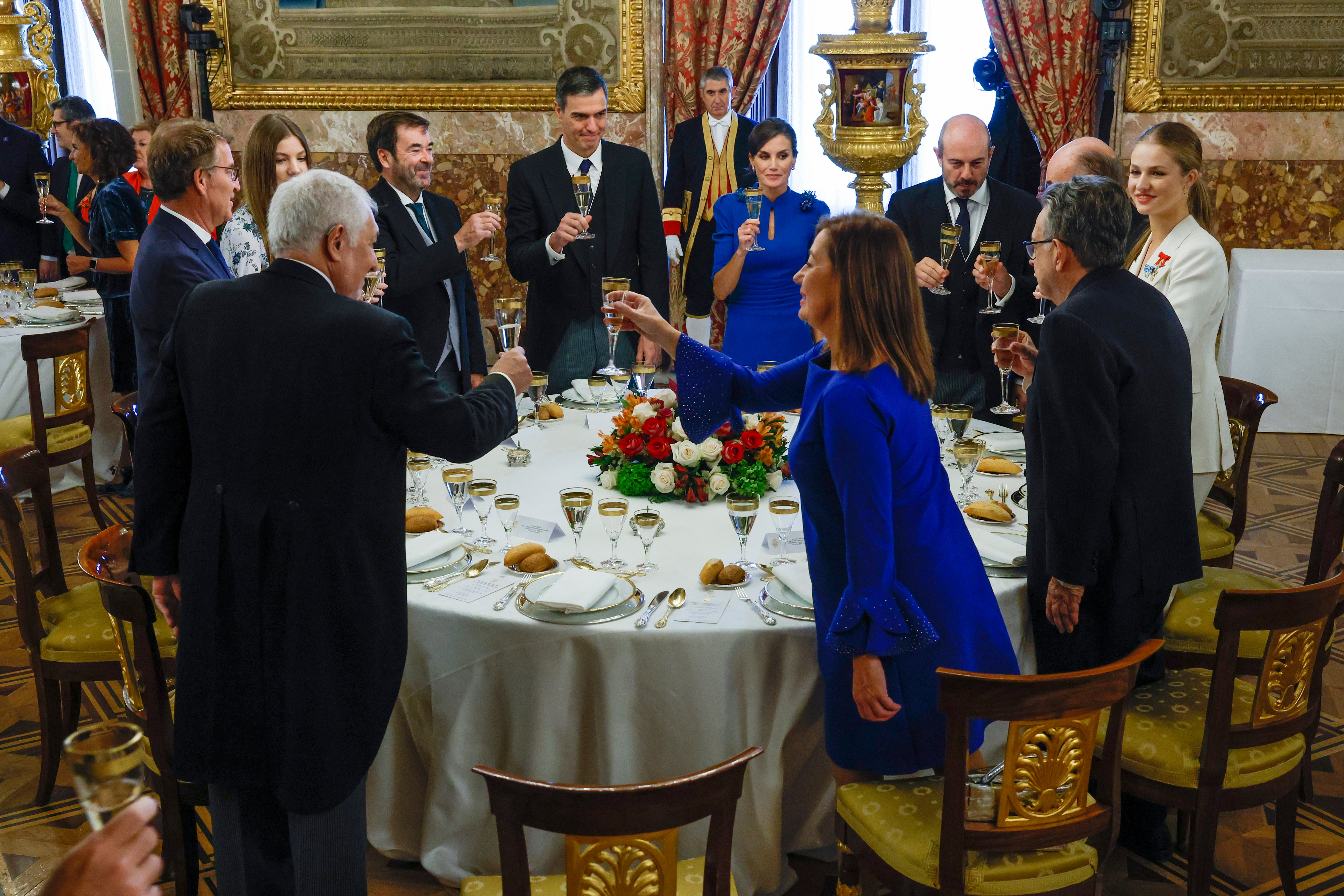 La Princesa, la Infanta y la Reina brindan con los comensales que le acompañan en la mesa antes de almorzar en Palacio