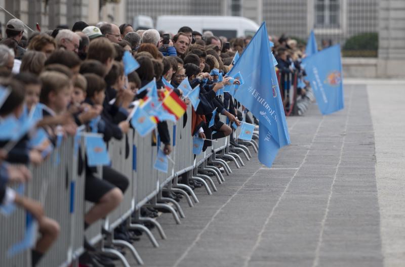 Alumnos procedentes de los colegios de las zonas aledañas al Palacio Real aguardan la llegada de los Reyes, la Princesa y la Infanta