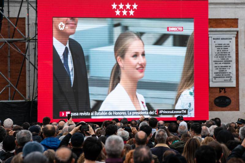 Una multitud de personas siguen en pantallas, preparadas para la ocasión, el Juramento de la Constitución de la Princesa Leonor, en la Puerta del Sol
