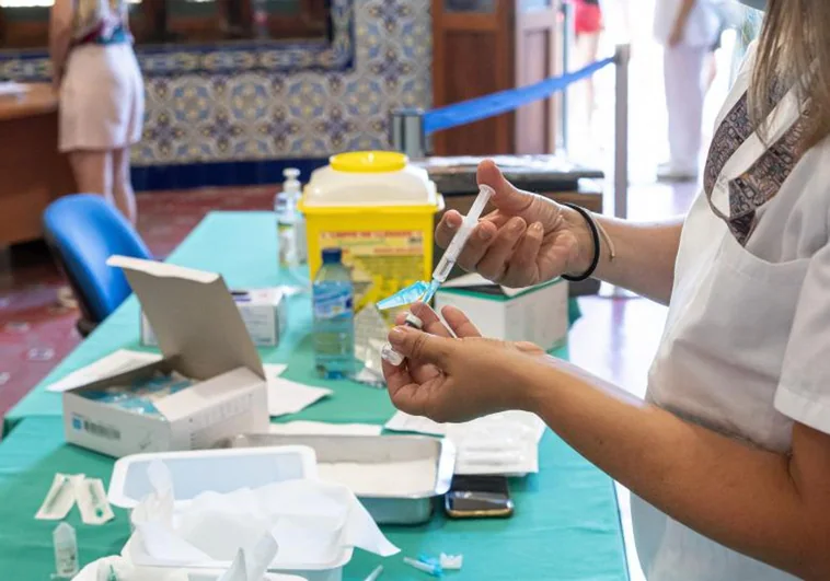 Imagen de archivo de una enfermera con un vial inyectable.