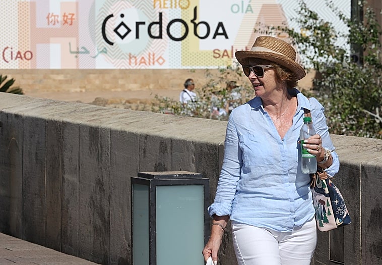 Una turista pasea por el Puente Romano de Córdoba