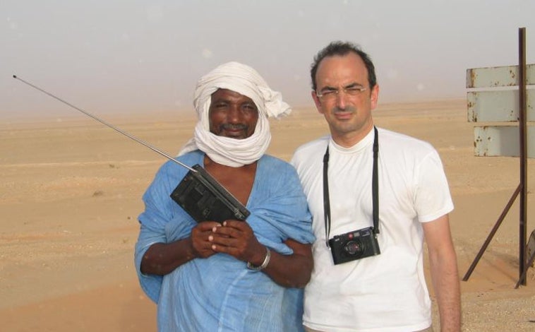 Imagen principal - 1. Desierto entre Nuakchot y Nouadhibou. Quintela posa con un pastor de cabras escuchando una radio. 2. El capitán del cayuco, en primer plano, en uno de los pocos momentos en que el reportero pudo hacer una foto. 3. La tripulación de la patrullera de Guardia Civil río Duero se fotografió con el periodista, después de que se recuperase, pasadas dos horas del rescate