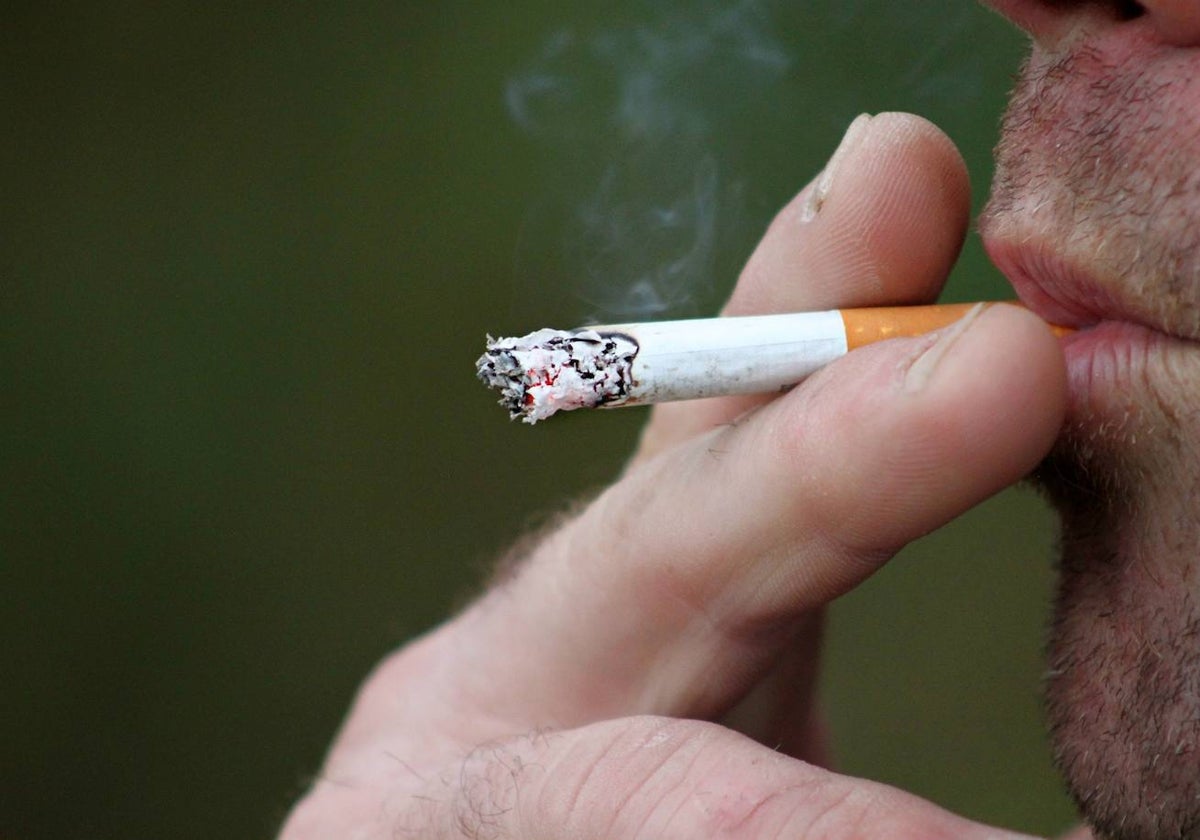 Un hombre se fuma un cigarrillo