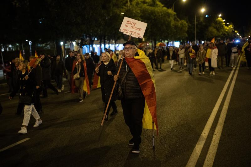 Un hombre con una bandera de España parte junto a otras personas hacia la calle Ferraz tras una concentración contra la amnistía frente al Parlamento Europeo