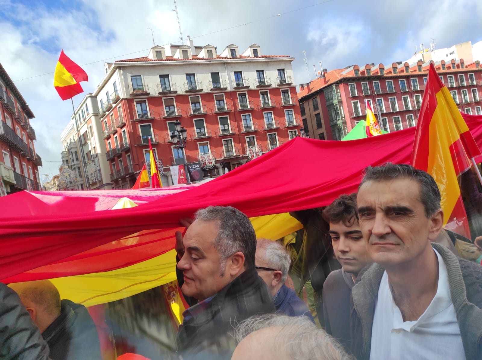 Manifestantes de Valladolid estiran una gran bandera de España sobre la gente. Asistentes a las protestas en Valladolid: más de 25.000