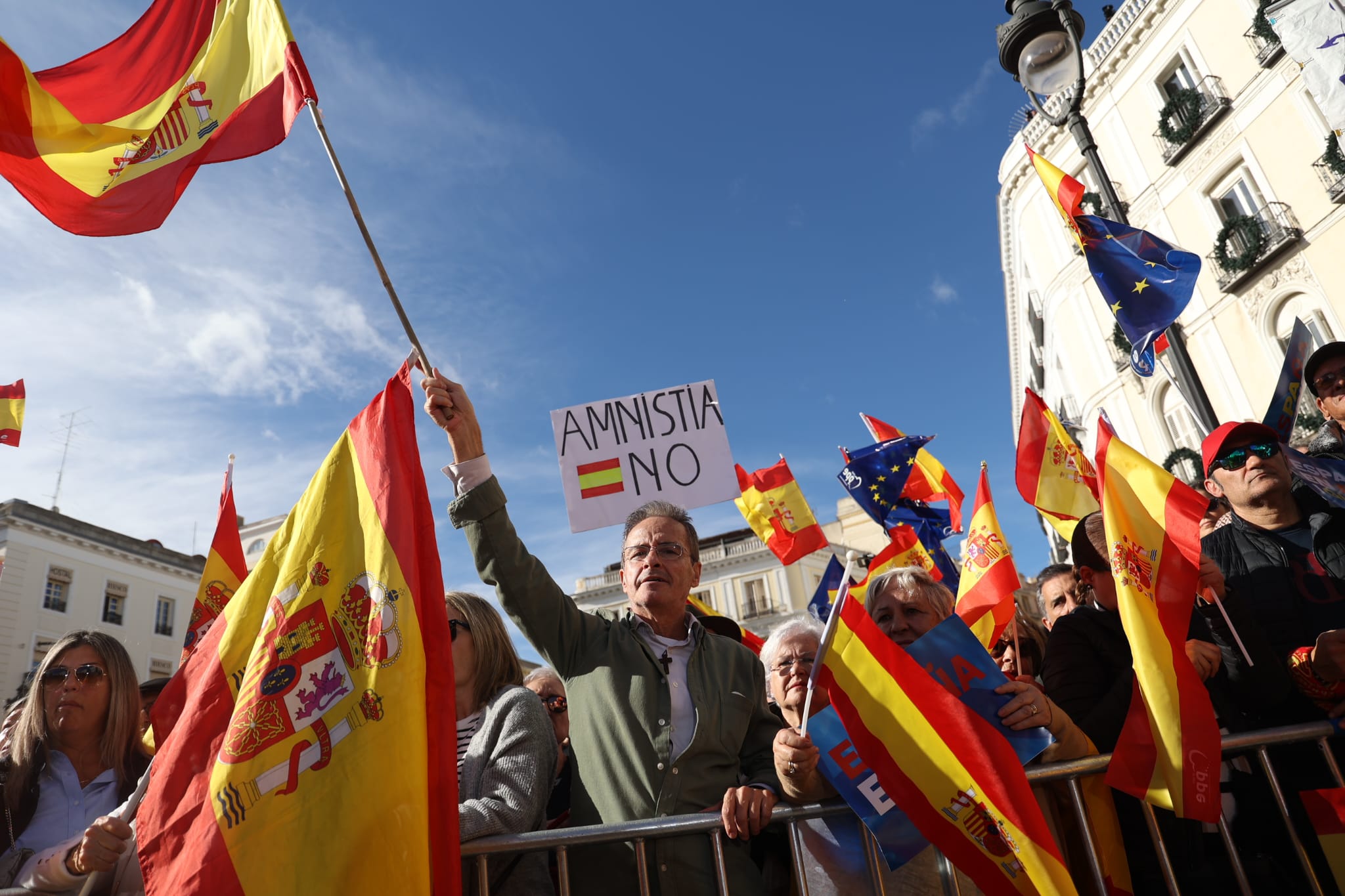 Un manifestante agita una bandera de España en la Puerta del Sol. Asistentes a las protestas en Madrid: medio millón según el Partido Popular