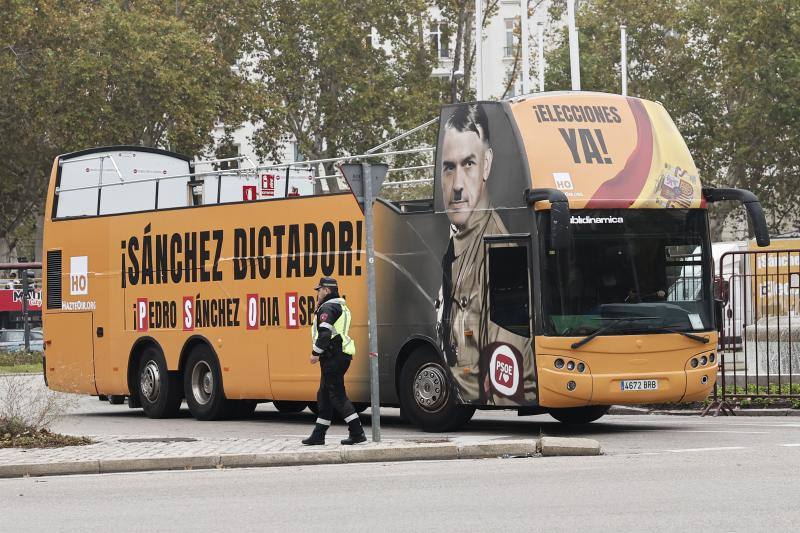 Vista del autobús de Hazteoir circulando junto a la fuente de Neptuno, en el que se exhibe un montaje que presenta a Pedro Sánchez caracterizado como Hitler