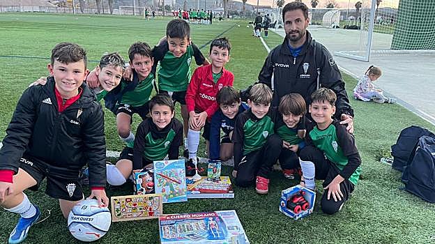 Jugadores del Benjamín A del Córdoba CF mostrando los regalos que aportarán a la campaña del club