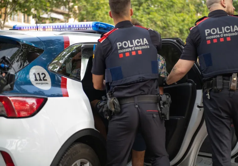 Agentes durante el traslado de un detenido en una patrulla