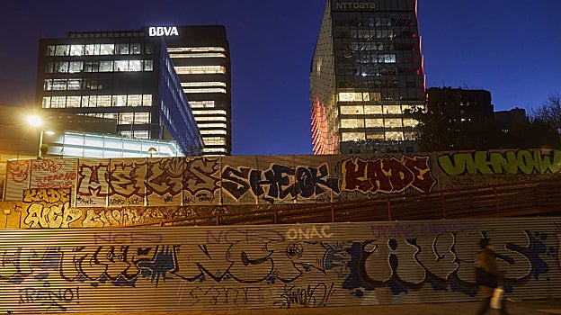 Las torres de oficinas de Azca se levantan sobre vallas grafiteadas