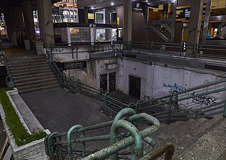 Imagen secundaria 1 - En la imagen principal, el paseo entre la calle Orense y la plaza de Azca donde se rematan las obras de un edificio de oficinas. Después, una de las escaleras retorcidas que terminan en rincones oscuros. En algunos, los vecinos han colgado carteles para advertir a los sintecho. 