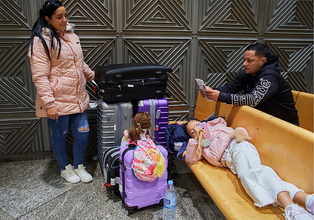 Elizabeth, Ronan y su hija Antonella esperan este lunes en Atocha a que salga su tren a Jaén, retrasado por la avería en el túnel de Recoletos