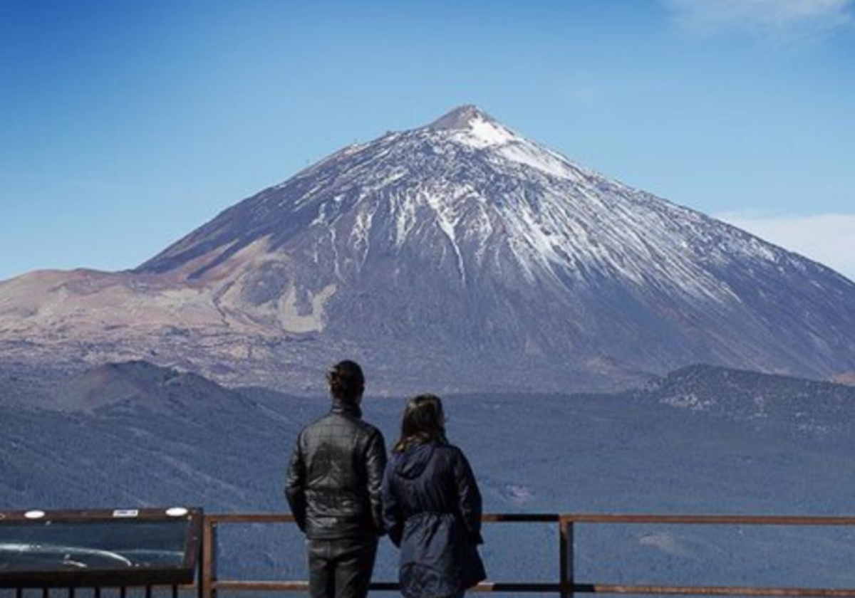 Dos personas observan el Teide desde su base