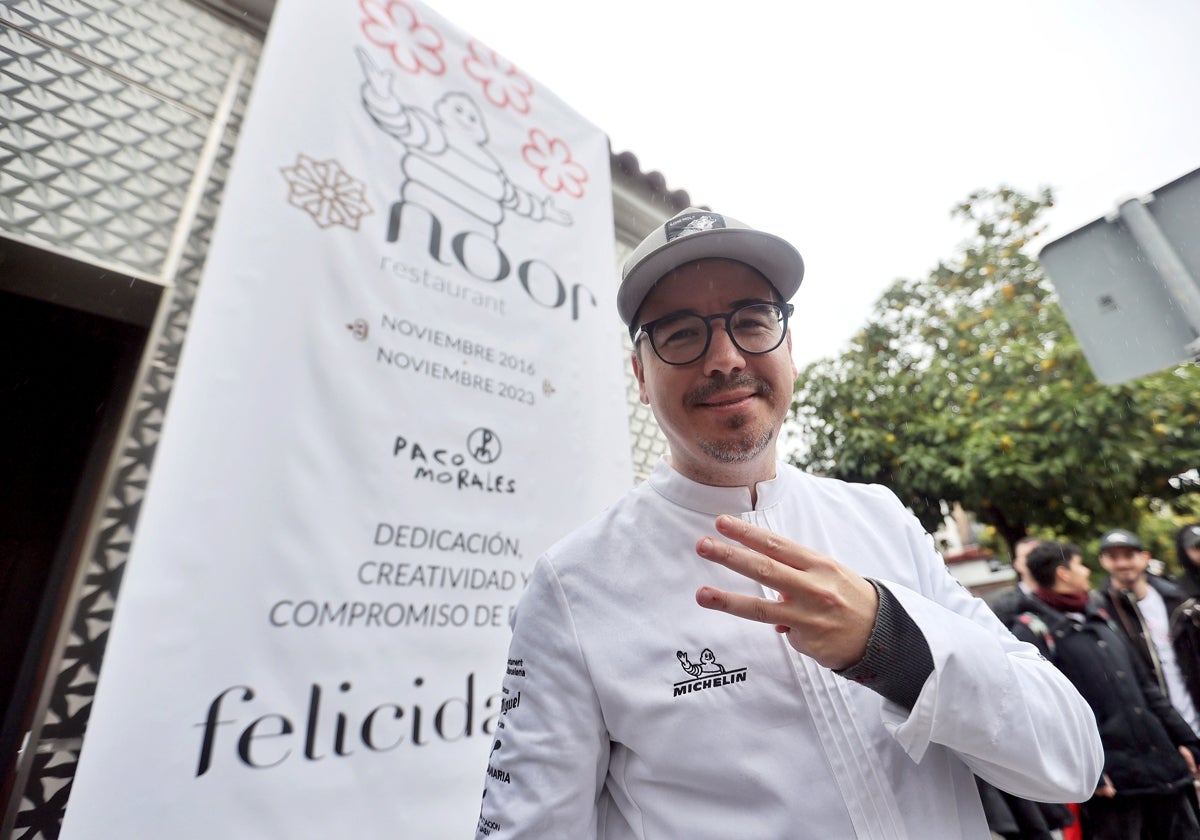Paco Morales levante los tres dedos de su mano ante su restaurante Noor en Cañero tras el reconocimiento Michelin