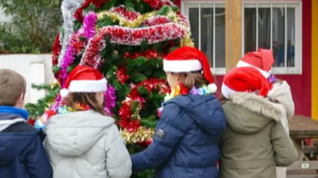 Niños decorando un árbol navideño en el Marché de Noël del Lycée Français International Molière