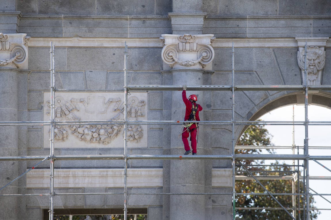 Un operario retira un andamio del costado sur, el pasado 21 de noviembre, la primera parte de la Puerta de Alcalá en destaparse.